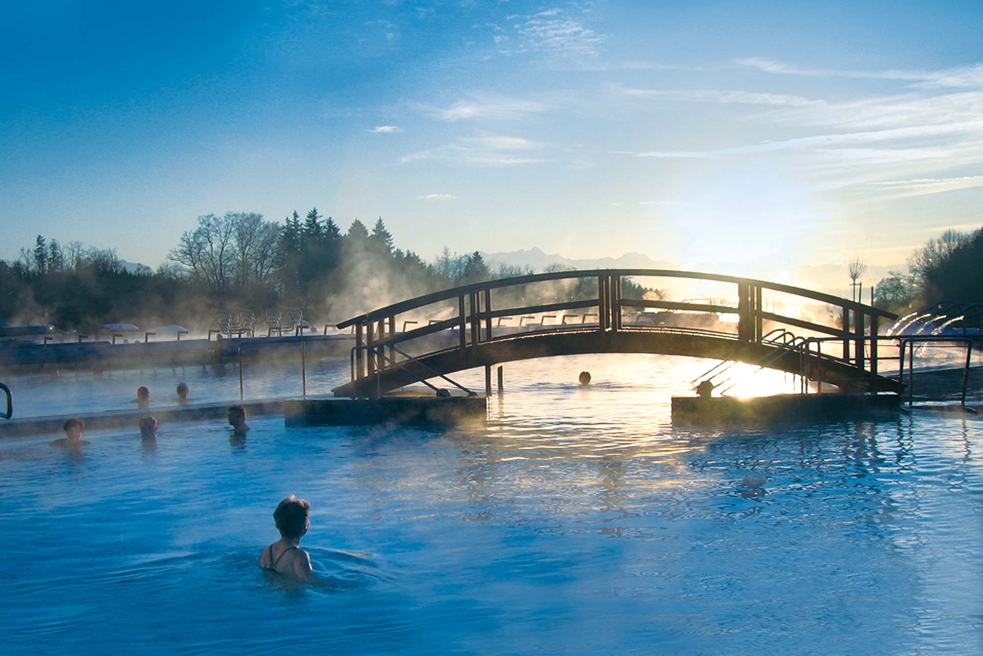 Badende Gäste eines Schwimmbades nutzen die vielen Freizeitaktivitäten, die die Chiemsee-Alpenland-Region bietet